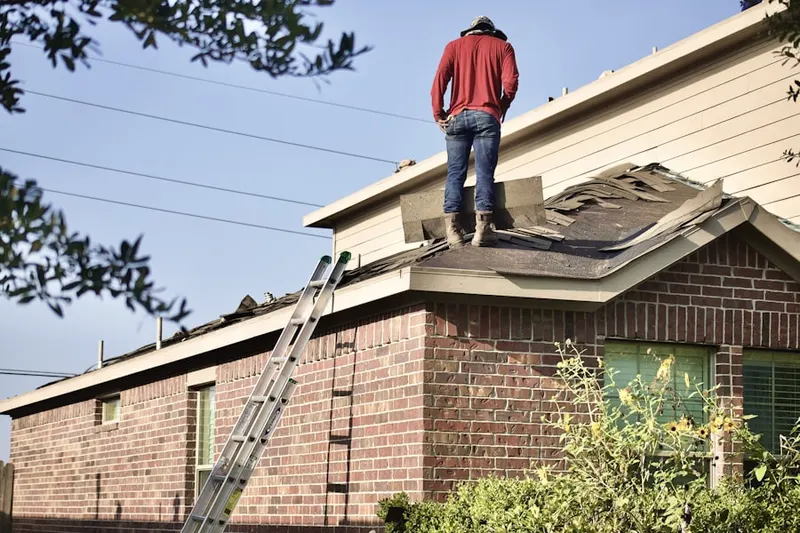 Professional roofer working on a residential roof in Rich Hill